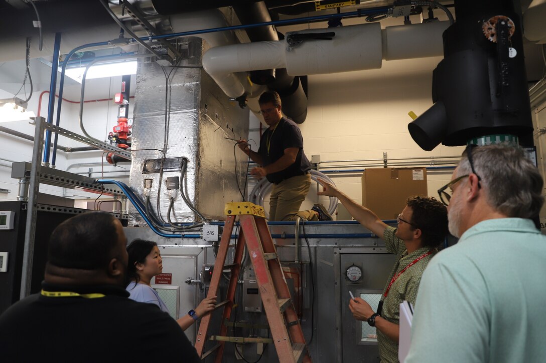 Practicum instructor Jay Tulley, research engineer (second from right), at the U.S. Army Engineer Research and Development Center’s Construction Engineer Research Laboratory (ERDC-CERL), guides a hands-on learning activity in the Dedicated Outdoor Air System at ERDC-CERL.