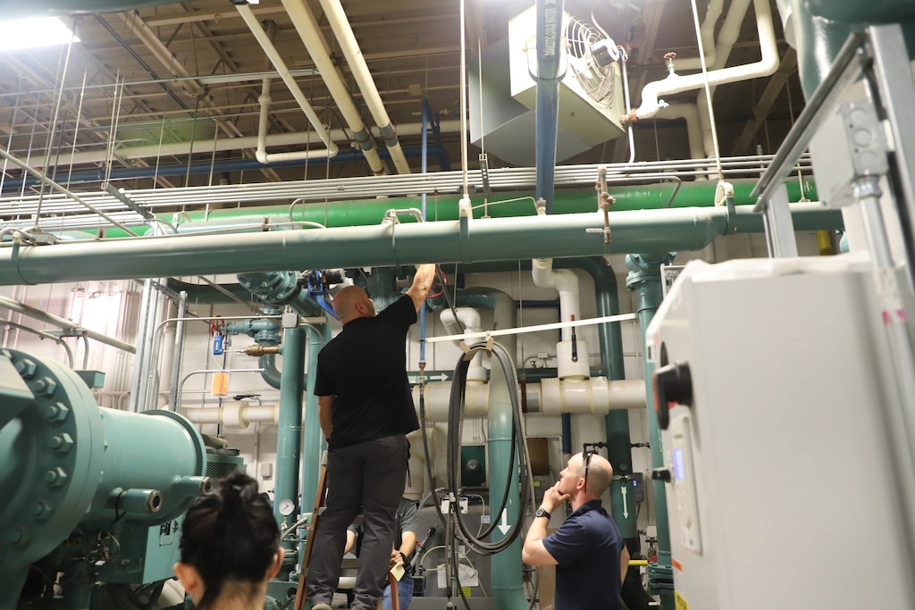 Practicum instructor Brian Clark (right), research mechanical engineer at the U.S. Army Engineer Research and Development Center’s Construction Engineer Research Laboratory (ERDC-CERL), observes students’ interactions with the equipment in the ERDC-CERL Central Utility Plant.