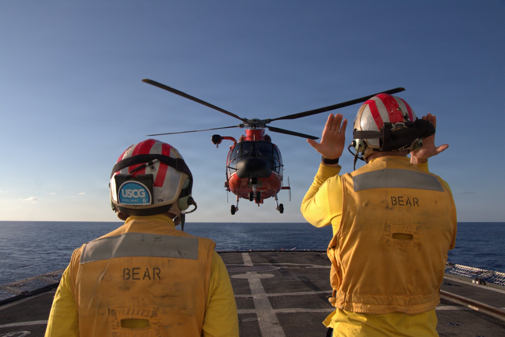 U.S. Coast Guard Ensigns Joshua Beavis and Nicolas Butler, landing signals officers aboard the Coast Guard Cutter Bear (WMEC 901), conduct flight operations with an embarked Helicopter Interdiction Tactical Squadron (HITRON) MH-65 Dolphin helicopter in the Southern Caribbean Sea, April 27, 2026. Beavis and Butler stood watch as LSOs to direct the flight crew during multiple daytime landing evolutions designed to maintain shipboard landing proficiency. (U.S. Coast Guard photo by Petty Officer 1st Class Kimberly Treece)