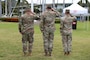 The back side of three male Army Soldiers saluting the flag