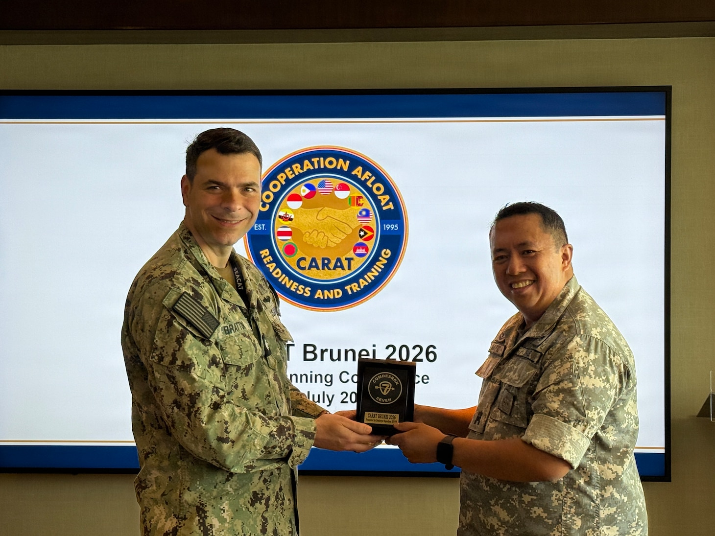 U.S. Navy Cmdr. Bert Bratton, chief, U.S. Military Group, presents a memento to Royal Brunei Air Force Maj. (U) Pg Muhd Mufid bin PG Haji Umar Arriffin, Staff Officer Grade 1, Joint Force Headquarters J7, at the Cooperation Afloat Readiness and Training (CARAT) Brunei 2026 Final Planning Conference in Bandar Seri Begawan, July 2, 2026.