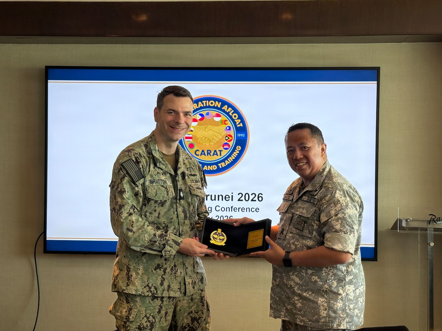 Royal Brunei Air Force Maj. (U) Pg Muhd Mufid bin PG Haji Umar Ariffin, Staff Officer Grade 1, Joint Force Headquarters J7 presents a memento to U.S. Navy Cmdr. Bert Bratton, chief, U.S. Military Group, at the Cooperation Afloat Readiness and Training (CARAT) Brunei 2026 Final Planning Conference in Bandar Seri Begawan, July 2, 2026.