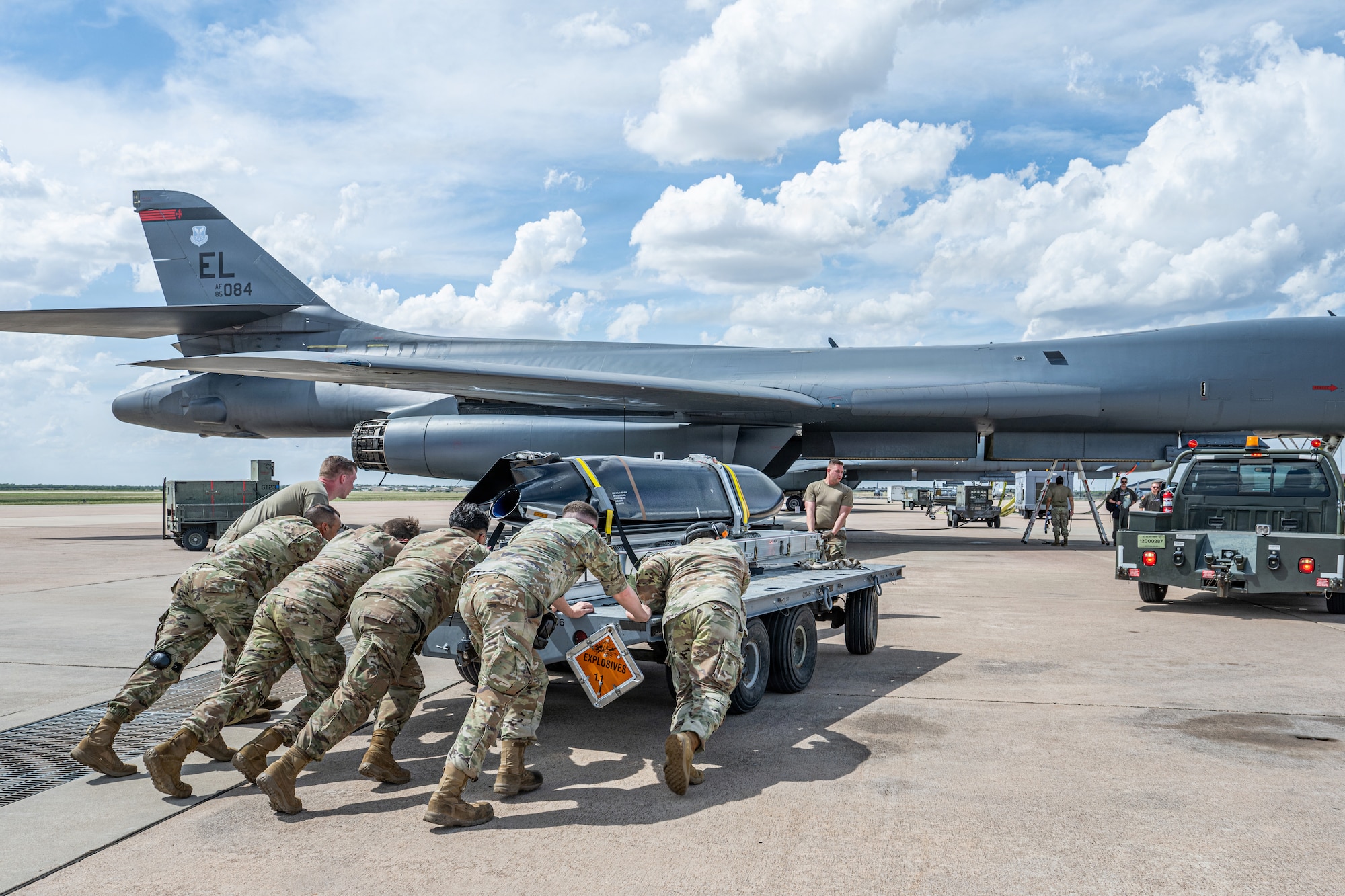 Airmen work on the flightline next to a B-1B Lancer