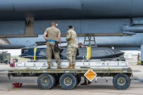 Airmen work on the flightline next to a B-1B Lancer