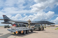 Airmen work on the flightline next to a B-1B Lancer