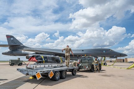 Airmen work on the flightline next to a B-1B Lancer