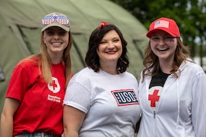 Three community volunteers from American Red Cross and USO pose for a photo as they help soldiers celebrate America’s 250th anniversary with morale‑boosting events and services in Poland July 4, 2026. Soldiers took some downtime to celebrate 250 years of freedom and independence. (U.S. Army photo by Sgt. Roberto Diaz)
