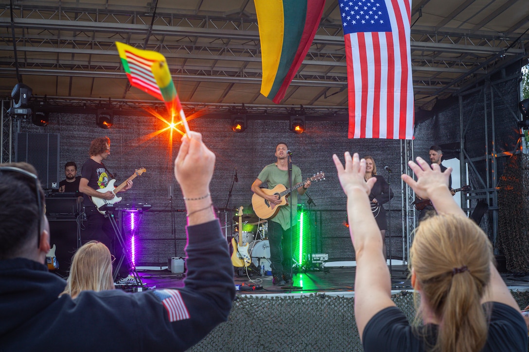 A Lithuanian band, the Michael Frishman Show, performs on stage for U.S., Lithuanian and German service members during a celebration at Pabradė Training Area, Lithuania, July 3, 2026. Service members waved Lithuanian and U.S. flags from the crowd as the concert was held in part of a day of celebration  of both the 250th anniversary of the United States’ independence on July 4th and Lithuanian Statehood Day, observed July 6 in commemoration of the 1253 coronation of King Mindaugas. V Corps is the U.S. Army's only forward-deployed corps, serving as the senior tactical headquarters for Army forces in Eastern Europe to deter conflict and provide combat-ready forces alongside our NATO Allies. V Corps is operationalizing and expanding the Eastern Flank Deterrence Initiative with Allies, rapidly integrating emerging technologies into training and tactical plans.