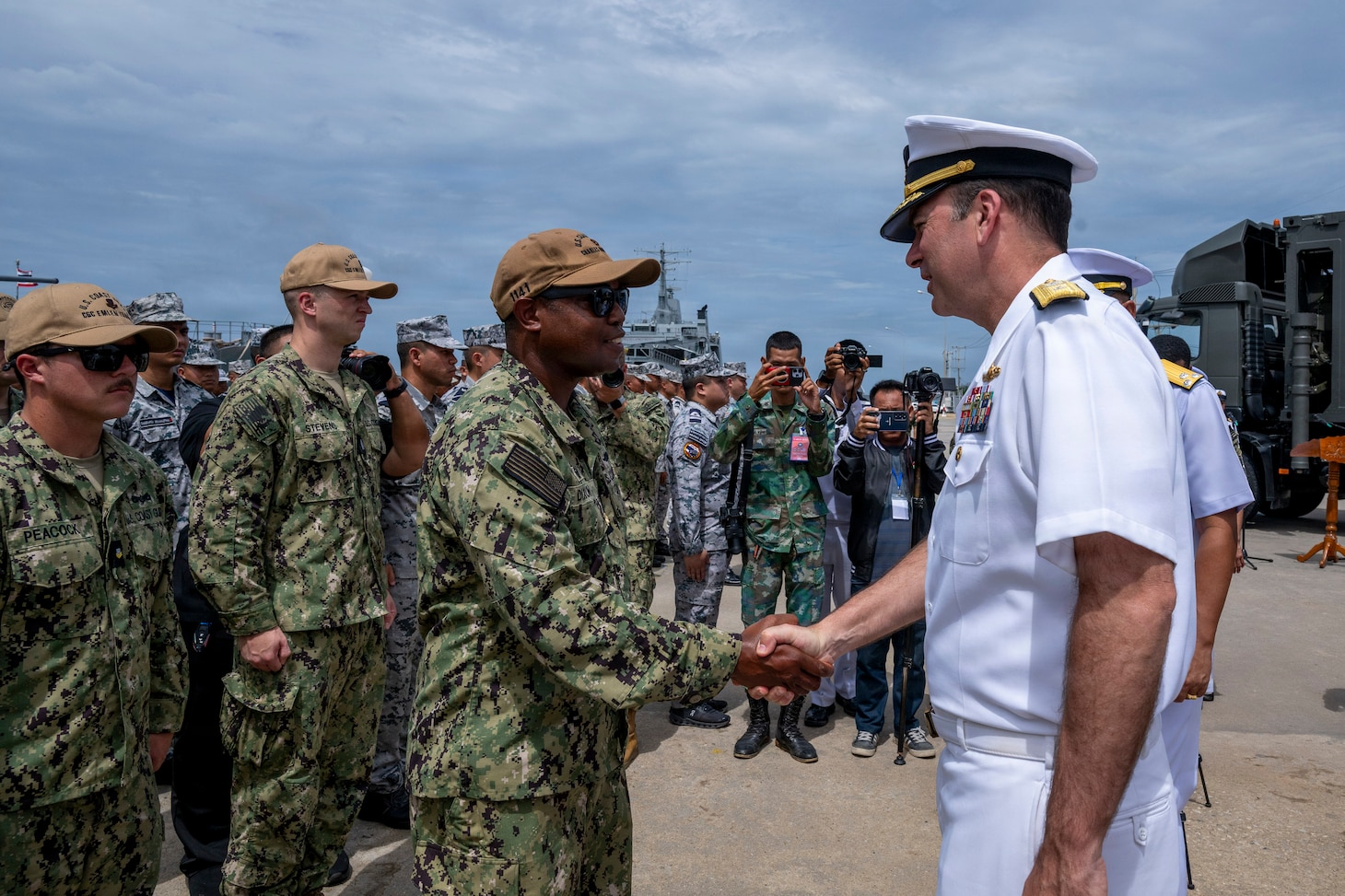 U.S. Navy Rear Adm. Kyle Gantt, deputy commander, U.S. 7th Fleet, greets U.S. Coast Guard Lt. Cmdr. Patrick Dixon, commanding officer of the Sentinel-class fast response cutter USCGC Charles Moulthrope (WPC 1141), during the opening ceremony of exercise Cooperation Afloat Readiness and Training (CARAT) Thailand 2026, July 6, 2026, at Laem Tian Pier.