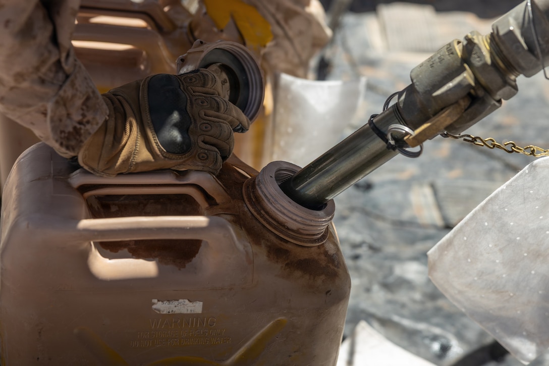 U.S. Marines with 8th Engineer Support Battalion, 2nd Marine Logistics Group, assigned to Joint Task Force-Southern Border, refuel a 5-gallon jerry can to power equipment used for barrier reinforcement operations along the southern border in Douglas, Arizona.