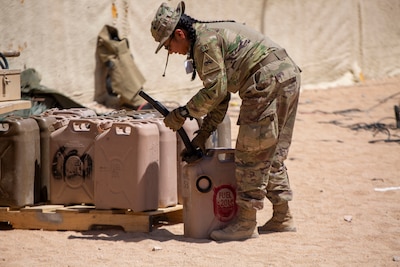 A U.S. Soldier assigned to 3rd Armored Brigade Combat Team, 1st Armored Division attaches a nozzle to a fuel can during Rotation 24-08 at the National Training Center, Fort Irwin, California.
