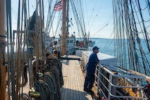 A U.S. Coast Guardsman stands on a boat.