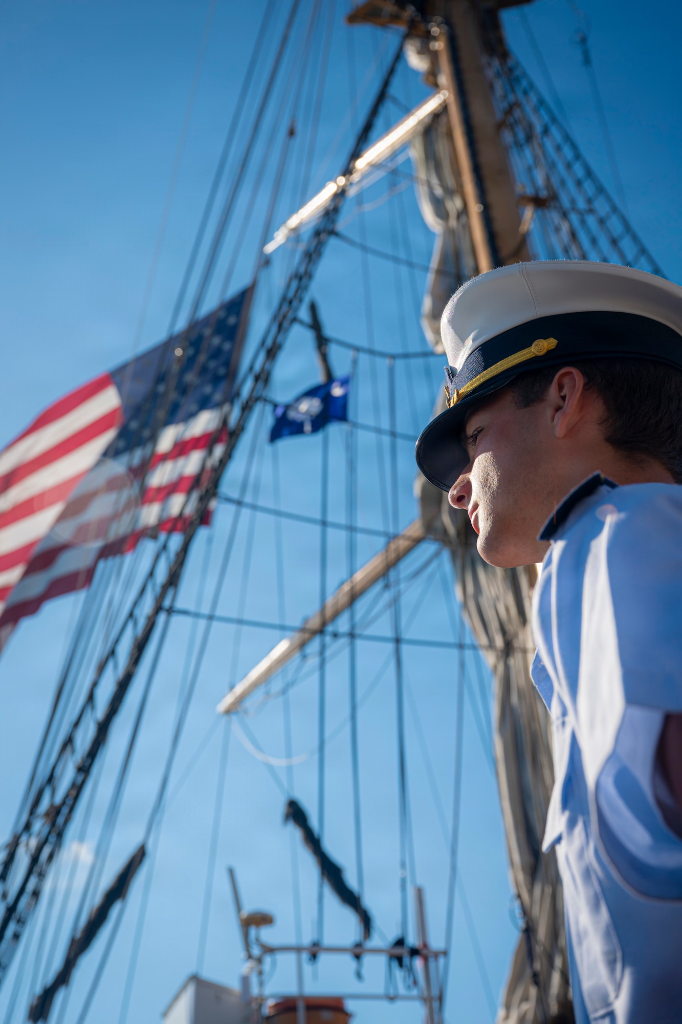 A U.S. Coast Guard Academy cadet looks out to the horizon on a boat.