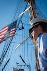 A U.S. Coast Guard Academy cadet looks out to the horizon on a boat.