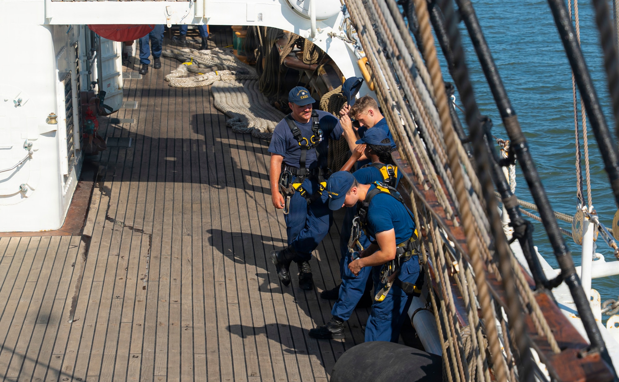 U.S. Coast Guard crew members converse with each other on a boat.