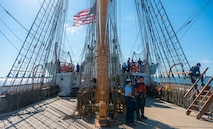 U.S. Coast Guardsmen converse with local residents on a boat.