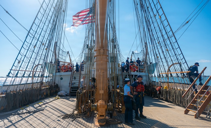 U.S. Coast Guardsmen converse with local residents on a boat.