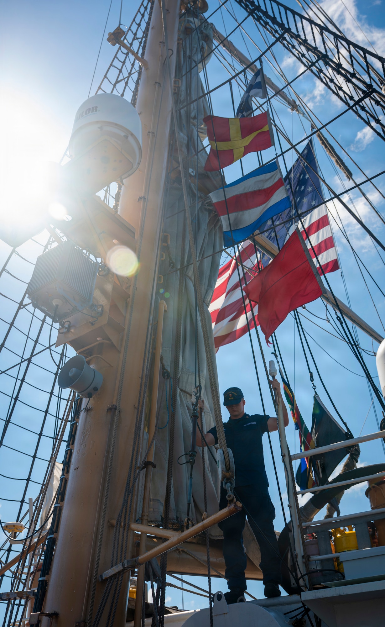 A U.S. Coast Guard Academy cadet stands on a boat.