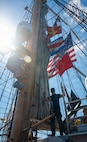 A U.S. Coast Guard Academy cadet stands on a boat.