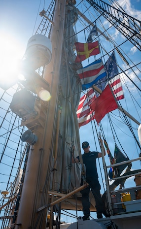 A U.S. Coast Guard Academy cadet stands on a boat.