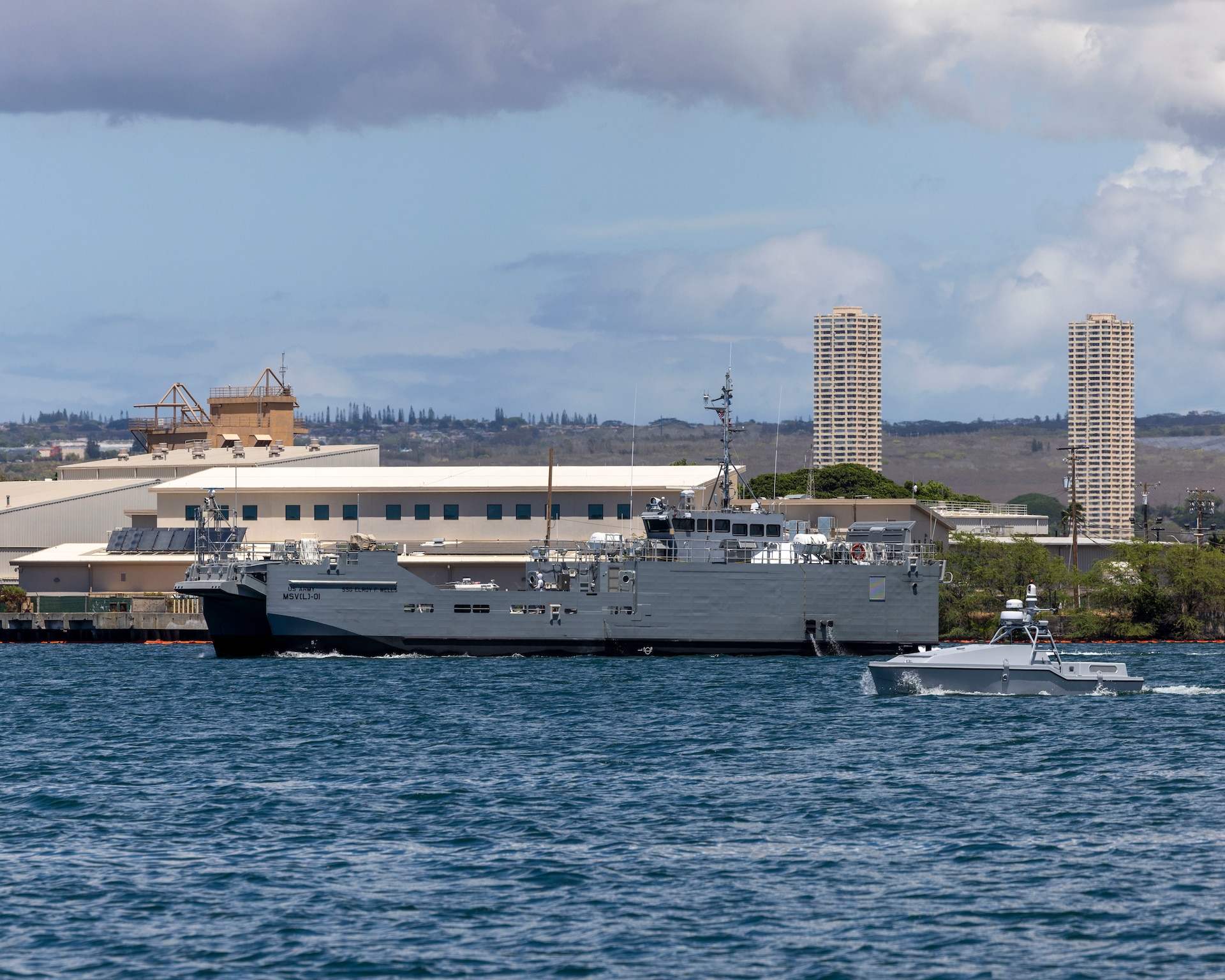 An autonomous watercraft conducts a patrol along side USAV SSG Elroy F. Wells (MSV 01) during the xTech Program competition off the shore of Joint Base Pearl Harbor-Hickam, Sep. 10, 2025.