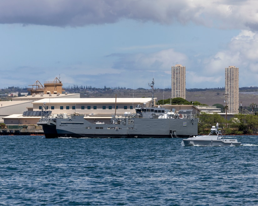 An autonomous watercraft conducts a patrol along side USAV SSG Elroy F. Wells (MSV 01) during the xTech Program competition off the shore of Joint Base Pearl Harbor-Hickam, Sep. 10, 2025.