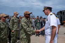 U.S. Navy Rear Adm. Kyle Gantt, deputy commander, U.S. 7th Fleet, greets U.S. Coast Guard Lt. Cmdr. Patrick Dixon, commanding officer of the Sentinel-class fast response cutter USCGC Charles Moulthrope (WPC 1141), during the opening ceremony of exercise Cooperation Afloat Readiness and Training (CARAT) Thailand 2026, July 6, 2026, at Laem Tian Pier.