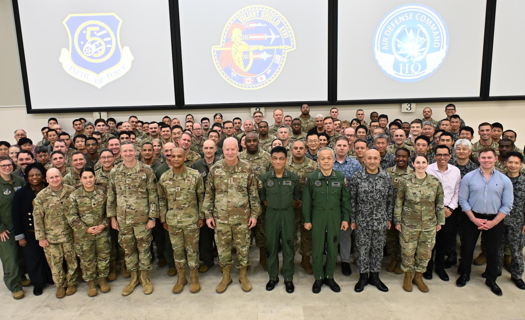 U.S. Air Force Lt. Gen. Joel Carry, 5th Air Force commander, and Japanese Air Self-Defense Force Lt. Gen. Lt Gen Hidemasa Inatsuki, JASDF Air Defense Command commander, pose with members of the bilateral air operations coordination center during exercise VALIANT SHIELD 2026 at Yokota Air Base, Japan, June 30. The ten-day field training exercise allowed Joint U.S. Service members to exchange subject matter expertise with allied militaries while strengthening partnerships, readiness, and coalition force capabilities. (U.S. Air Force photo by 1st Lt. Anthony Highland)