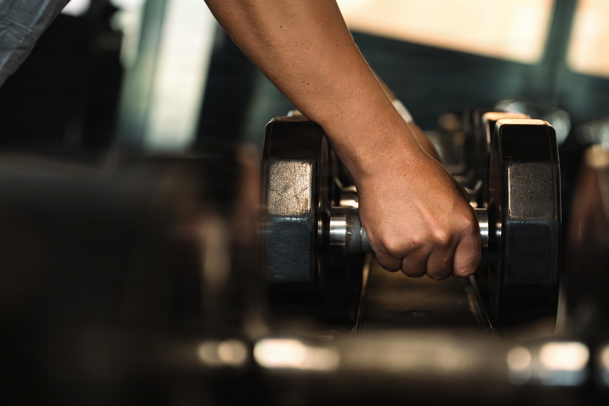 U.S. Air Force Airman 1st Class Baldemar Campos, 86th Maintenance Operations maintenance scheduler, grabs dumbbells from the weight rack in the Southside Fitness Center at Ramstein Air Base, Germany, June 11, 2026.