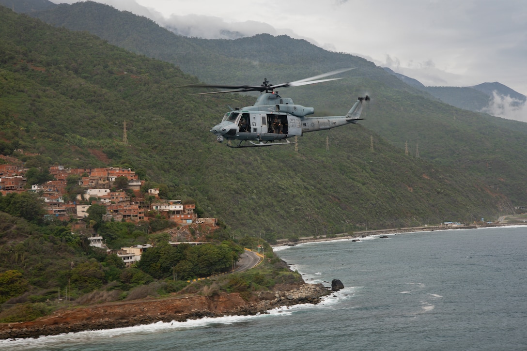 A U.S. Marine Corps UH-1Y Venom assigned to Marine Medium Tiltrotor Squadron (VMM) 365 (Reinforced), Littoral Combat Force-24, flies during Operation Deliver Aid, along the coast of La Guaira, Venezuela, June 3, 2026. At the direction of U.S. Southern Command, assigned U.S. military forces are supporting Department of State-led U.S. disaster assistance to the people of Venezuela in the aftermath of the June 24, 2026, earthquakes. (U.S. Marine Corps photo)