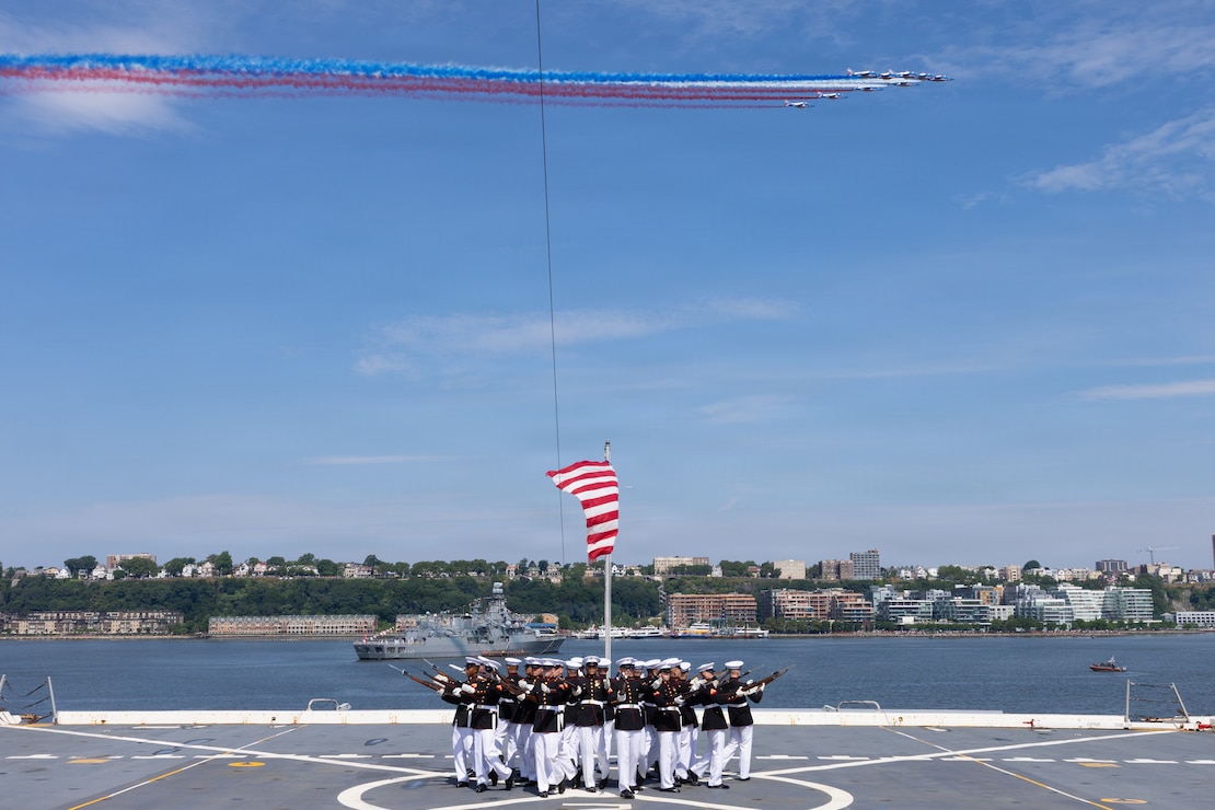 U.S. Marines with the Marine Corps Silent Drill Platoon perform their "bursting bomb" sequence as the United Arab Emirates Air Force AI Fursan aerobatic display team, show off capabilities of the Hongdu L-15 during a performance aboard the USS Arlington (LPD 24) in New York City, July 4, 2026. For 250 years, the U.S. Navy and Marine Corps stood the watch – constant, unabated in mission, faithfully preventing crisis and resolute in defending America’s independence. INR 250 honors the Navy, Marine Corps, and Coast Guard’s enduring role on, under, and above the seas. (U.S. Marine Corps photo by Lance Cpl. Michael Robinson)