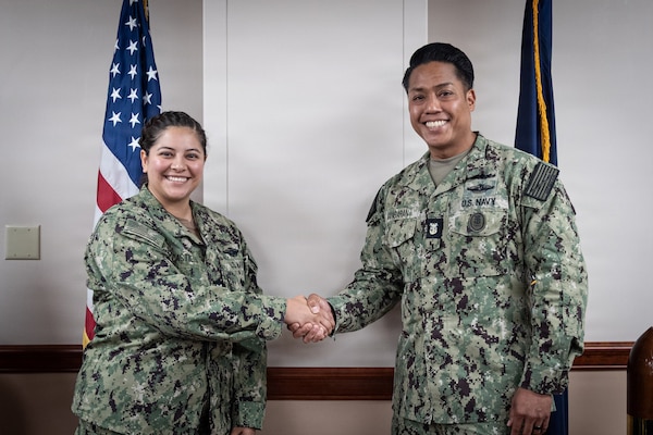 Navy Hospital Corpsman 3rd Class (Fleet Marine Force) Naleni Castillo receives a coin from Navy Force Master Chief PatrickPaul “PaP” C. Mangaran, command senior enlisted leader for the Defense Health Agency, in recognition of her exceptional service aboard Naval Health Clinic Cherry Point on Friday, June 26, 2026. Mangaran toured NHCCP for an update on latest development to facilities for patients and staff. NHCCP serves as the keystone of medical readiness for units assigned to Marine Corps Air Station Cherry Point.