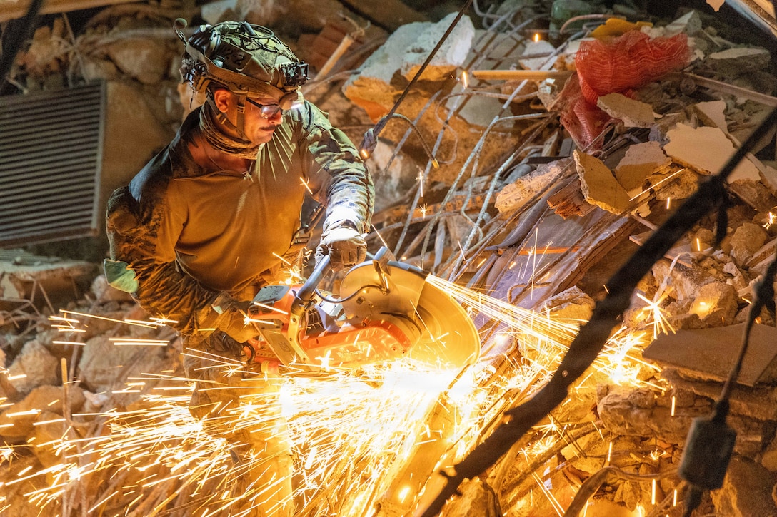 A U.S. Marine with Maritime Raid Force, Littoral Combat Force-24, cuts through rebar with an electric saw during a search and rescue in La Guaira, Venezuela, June 30, 2026. At the direction of U.S. Southern Command, assigned U.S. military forces are supporting Department of State-led U.S. disaster assistance to the people of Venezuela in the aftermath of the June 24, 2026, earthquakes. (U.S. Marine Corps photo)