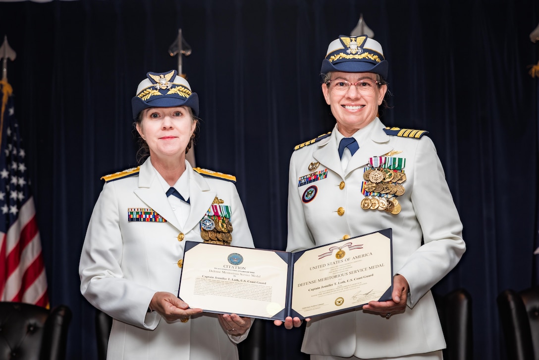 U.S. Coast Guard Rear Adm. Tiffany Danko (left), assistant commandant for Workforce Management, presents the Defense Meritorious Service Medal to Capt. Jennifer T. Loth, outgoing commanding officer of Coast Guard Reserve Unit United States Northern Command, during the unit's change of command ceremony at Peterson Space Force Base, June 12, 2026. During the ceremony, Loth transferred command of CGRU USNORTHCOM to Capt. Ian G. Brosnan. (Courtesy photo by Jhomil Bansil)