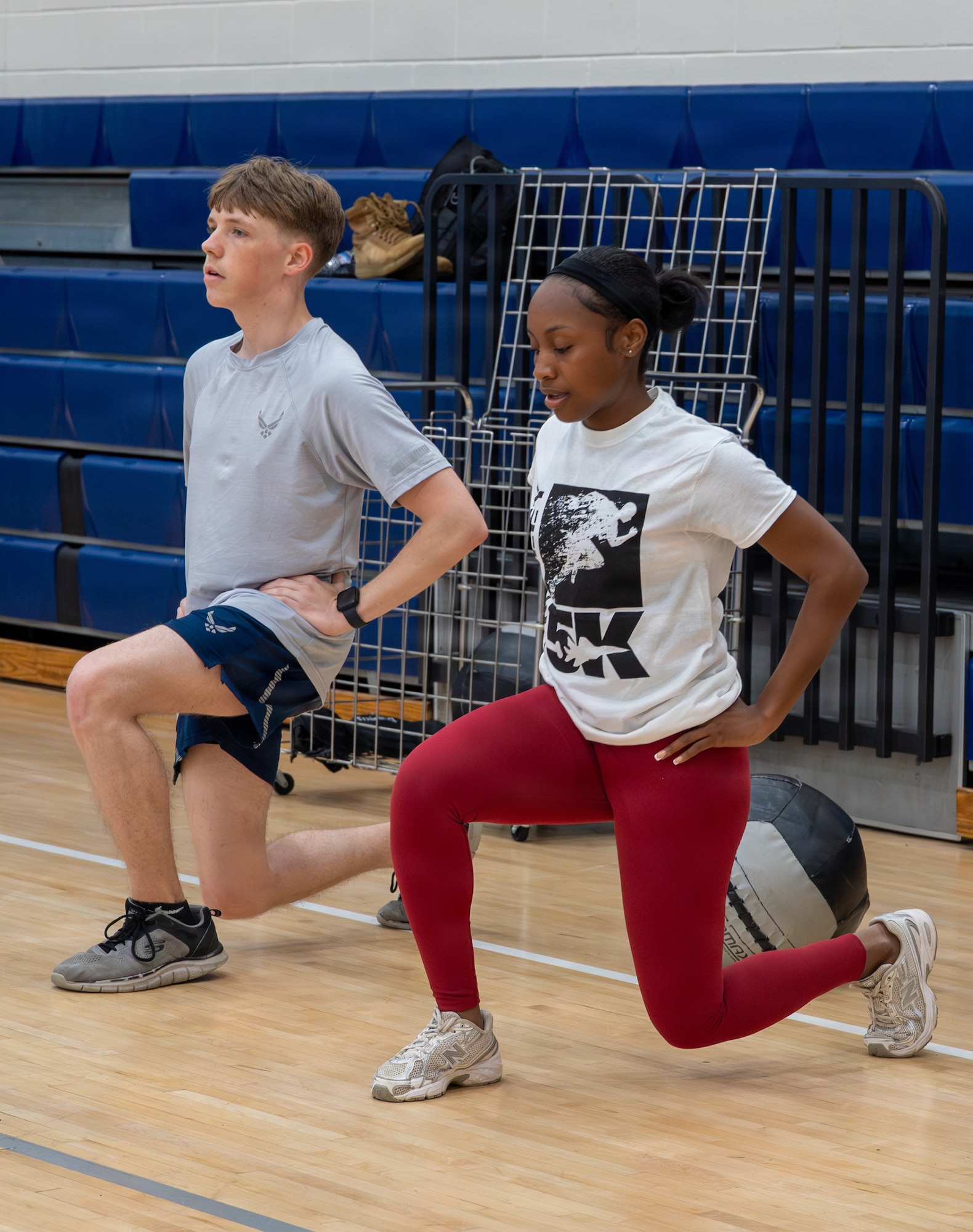 Two Airmen perform lunges.