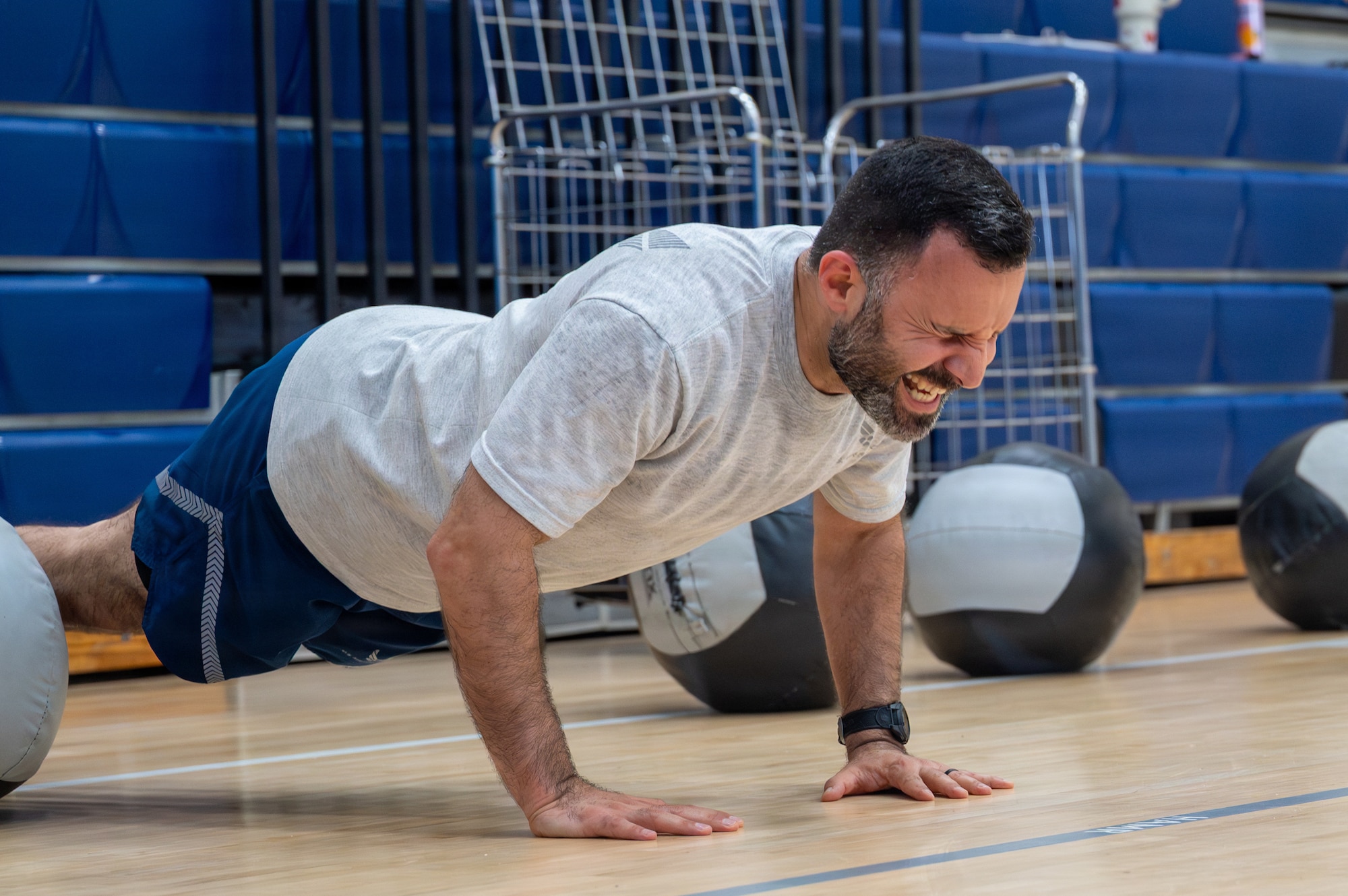 An Airmen planks in a gym.