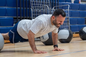 An Airmen planks in a gym.