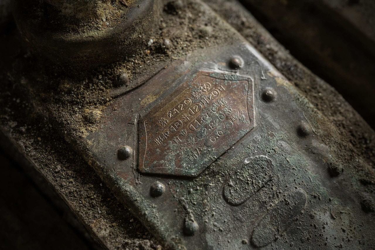 A close-up of an old engine component that is covered in dirt and dust.