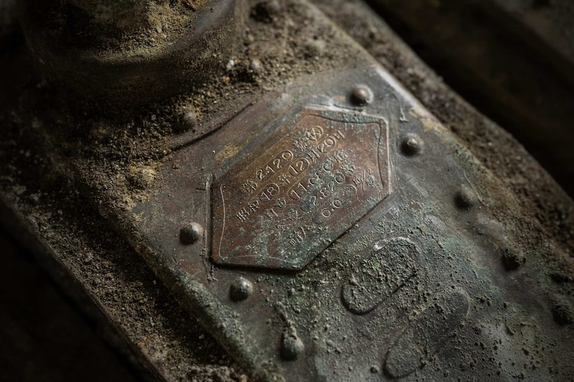 A close-up of an old engine component that is covered in dirt and dust.