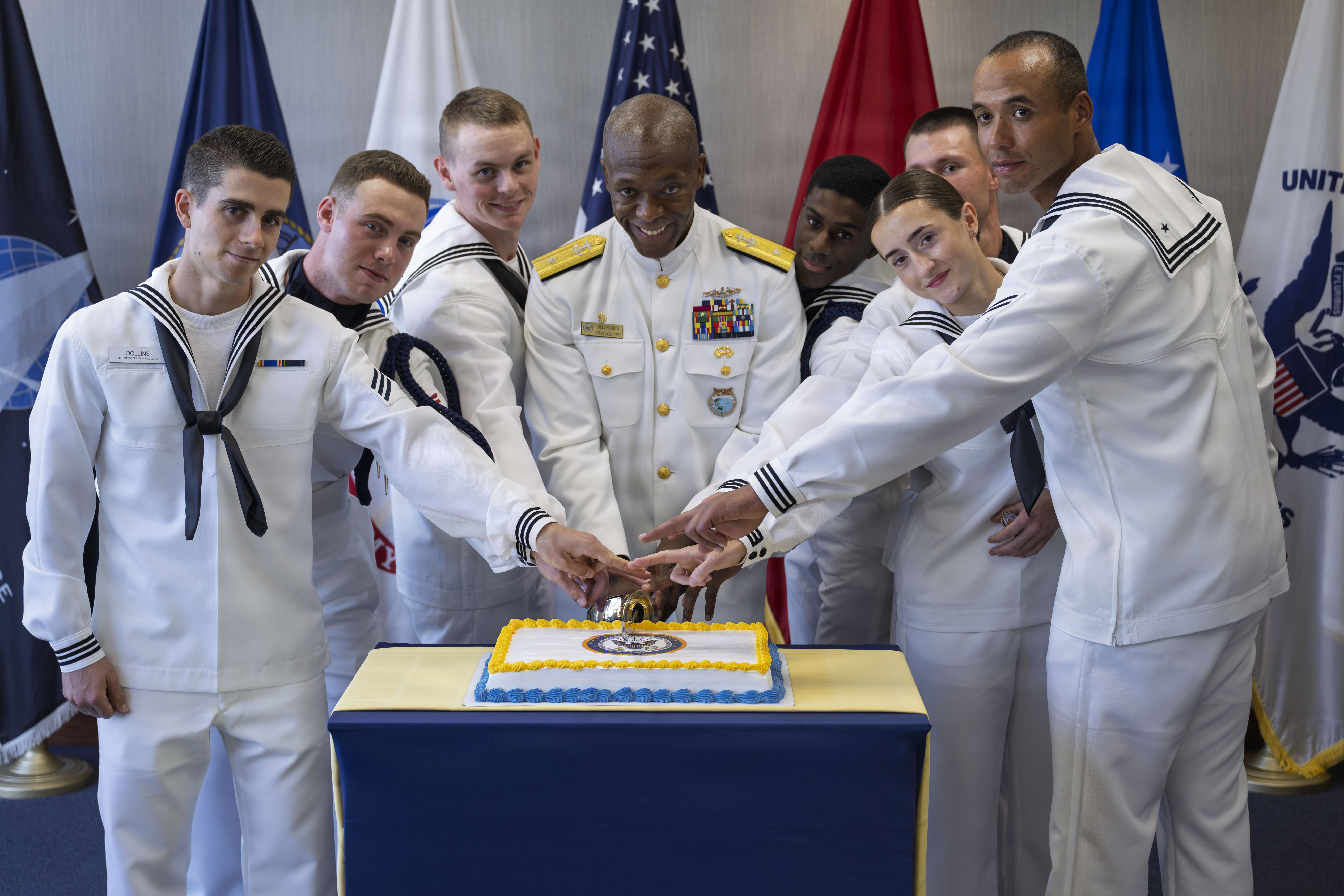 Rear Adm. Melvin Smith, Commander, Submarine Group Two, cuts a celebratory cake with Sailors following a pass-and-review ceremony at U.S. Navy Recruiting Command.