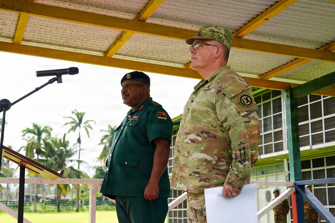 Papua New Guinea Defense Force’s Col. Michael Percy Marai, the commandant of Lae Area and U.S. Army Col. Jake Bledsoe, commander of the 4960th Multifunction Training Brigade, 9th Mission Support Command stand to recognize U.S. Army Soldiers from the 844th Engineer Battalion and Papua New Guinea Defense Forces as they march onto a parade field during the groundbreaking ceremony during Exercise Tamiok Strike 26 at Igam Barracks, Lae, Papua New Guinea, July 7, 2026.