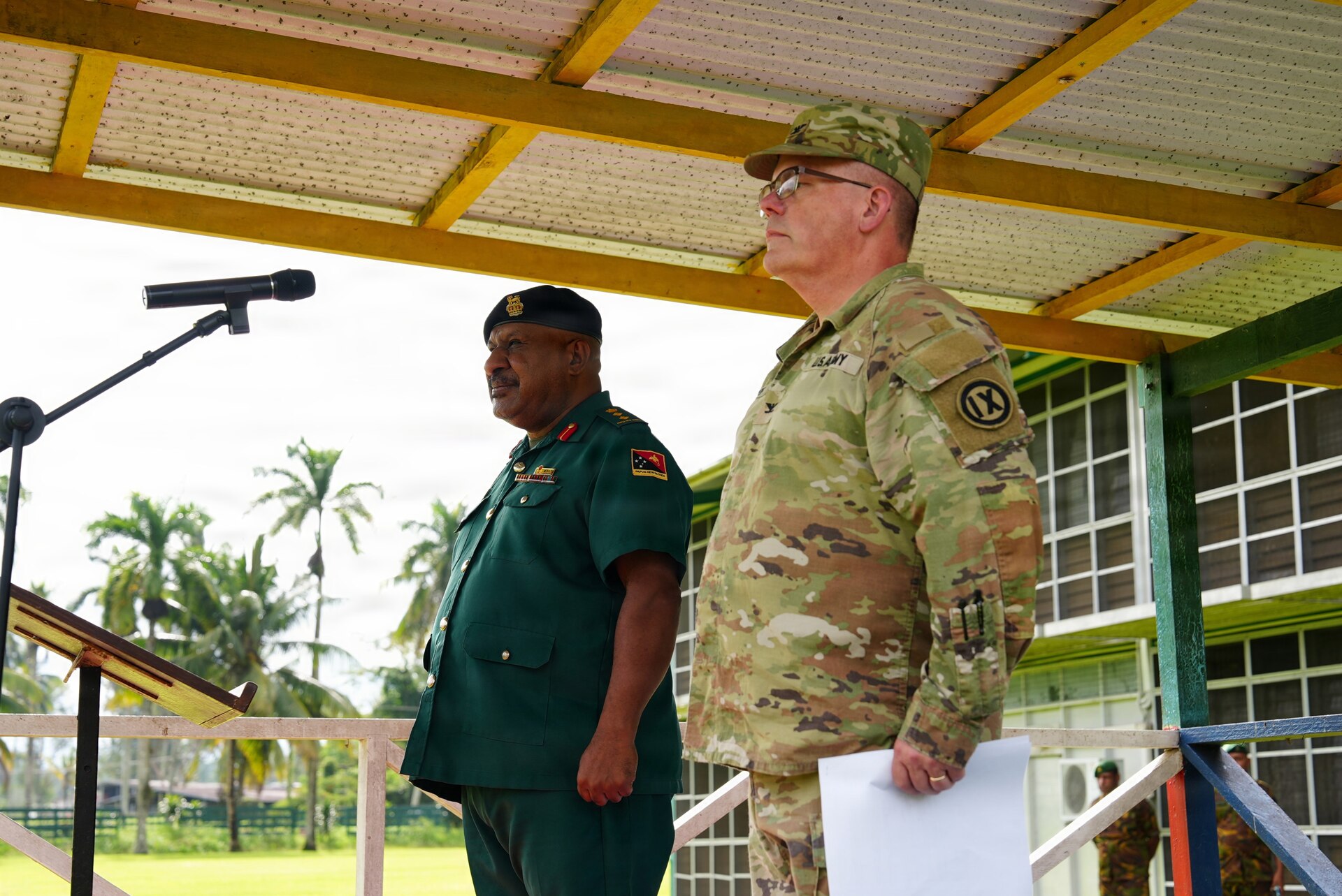Papua New Guinea Defense Force’s Col. Michael Percy Marai, the commandant of Lae Area and U.S. Army Col. Jake Bledsoe, commander of the 4960th Multifunction Training Brigade, 9th Mission Support Command stand to recognize U.S. Army Soldiers from the 844th Engineer Battalion and Papua New Guinea Defense Forces as they march onto a parade field during the groundbreaking ceremony during Exercise Tamiok Strike 26 at Igam Barracks, Lae, Papua New Guinea, July 7, 2026.