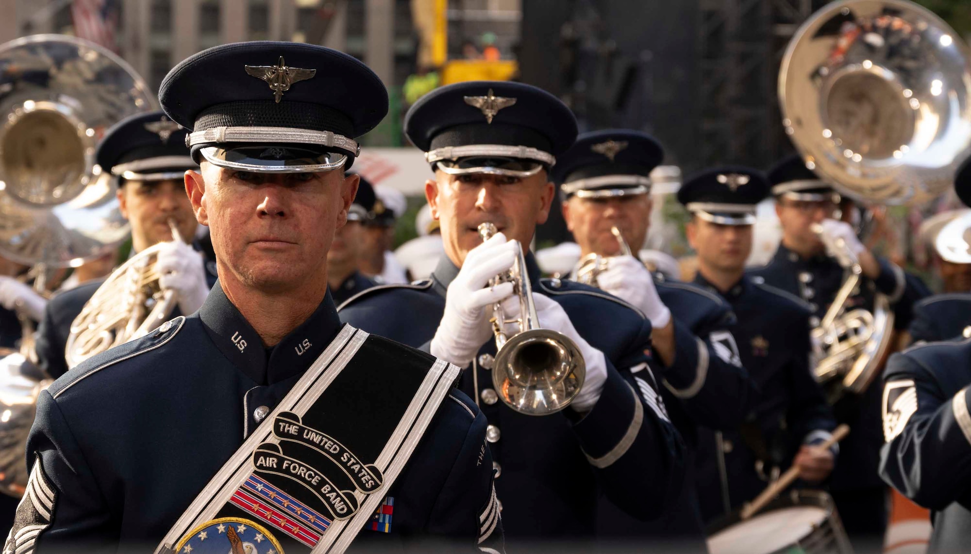 Airmen play silver instruments in formation.