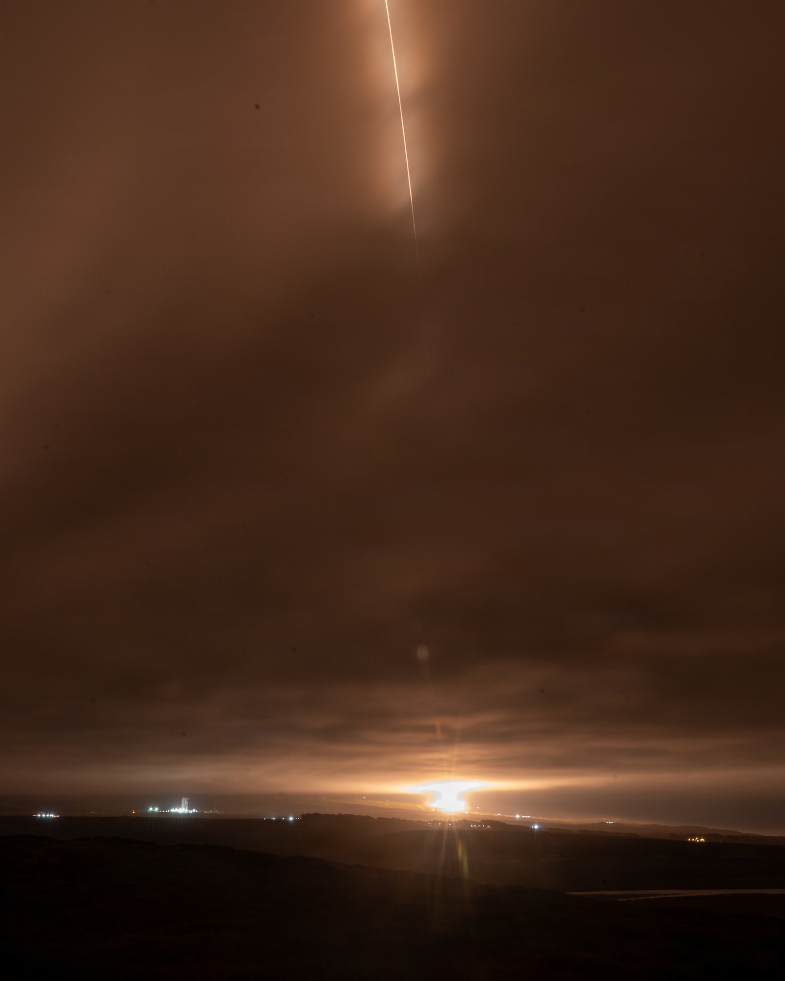 A streak of light traces the path of a rocket launch.