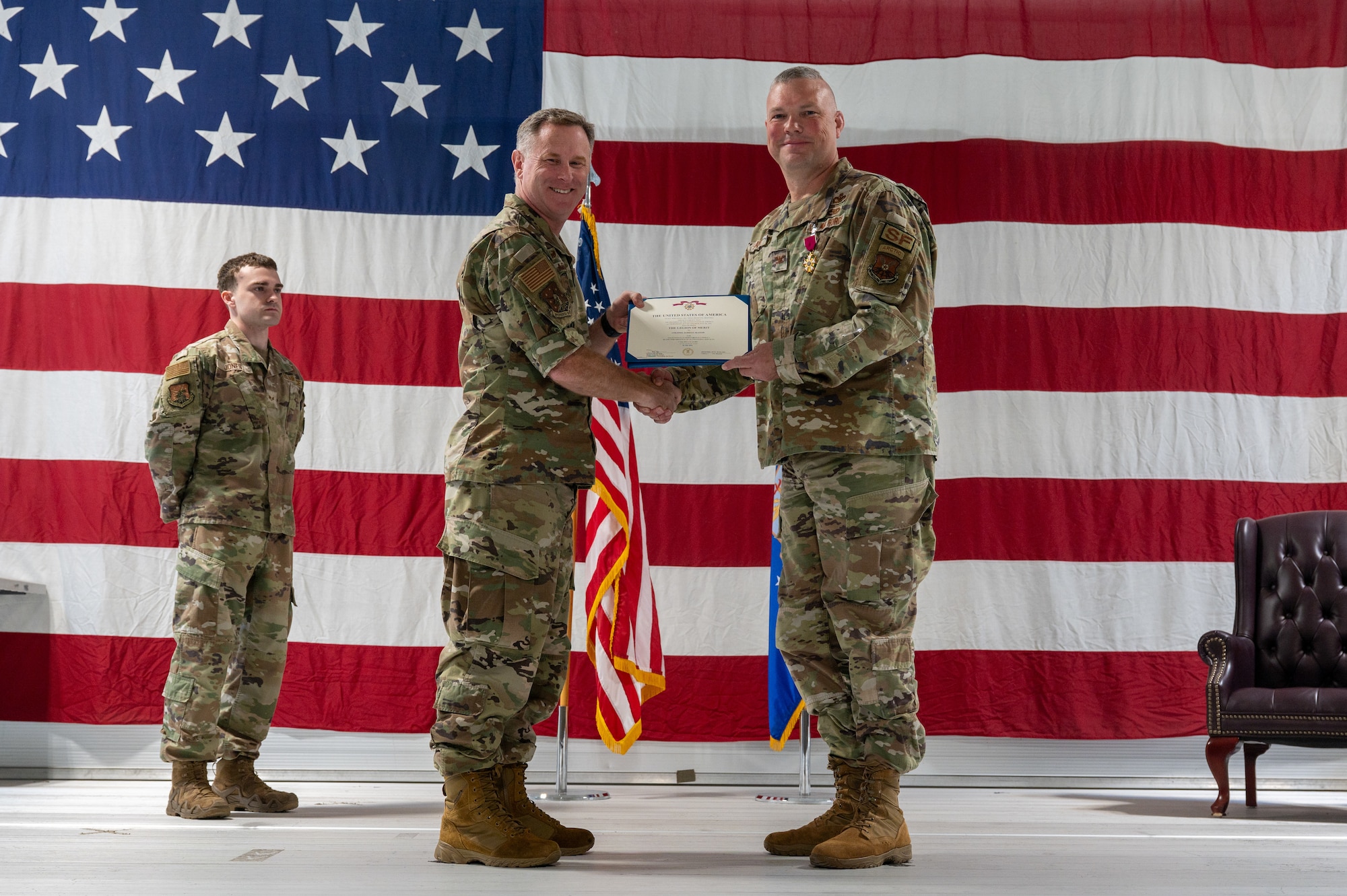 U.S. Air Force Col. James Slaton, 91st Security Forces Group (SFG) outgoing commander, right, receives the Legion of Merit certificate from U.S. Air Force Col. Jimmy Schlabach, 91st Missile Wing commander, during a change of command ceremony at Minot Air Force Base, North Dakota, July 1, 2026. As the 91st SFG commander, Slaton was primarily responsible for maintaining the security of the Minuteman III missile silos in the surrounding area.