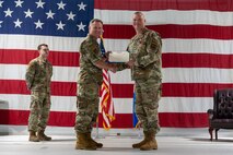 U.S. Air Force Col. James Slaton, 91st Security Forces Group (SFG) outgoing commander, right, receives the Legion of Merit certificate from U.S. Air Force Col. Jimmy Schlabach, 91st Missile Wing commander, during a change of command ceremony at Minot Air Force Base, North Dakota, July 1, 2026. As the 91st SFG commander, Slaton was primarily responsible for maintaining the security of the Minuteman III missile silos in the surrounding area.