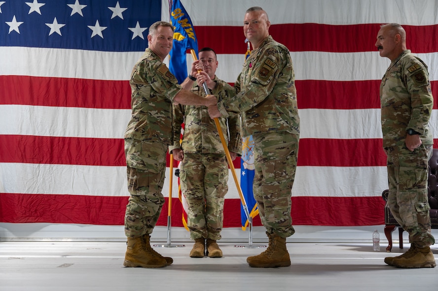 U.S. Air Force Col. Jimmy Schlabach, 91st Missile Wing commander, left, receives the guidon from U.S. Air Force Col. James Slaton, 91st Security Forces Group (SFG) commander, during a change of command ceremony at Minot Air Force Base, North Dakota, July 1, 2026. As the 91st SFG commander, Slaton was primarily responsible for maintaining the security of the Minuteman III missile silos in the surrounding area.