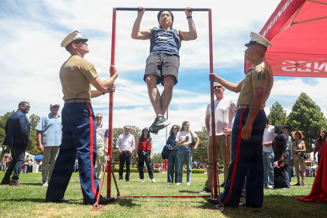 U.S. Marine Corps Capt. Benjamin Tucker, left, executive officer, and Sgt. Miguel Salinas, a canvassing recruiter, both with Recruiting Station San Diego, oversee a Marine Corps pull-up competition during the America 250 Festival at Liberty Station in San Diego, California, July 3, 2026. The America 250 Festival is a community event held to celebrate the 250th birthday of the United States of America. (U.S. Marine Corps photo by Cpl. Alejandro Fernandez)