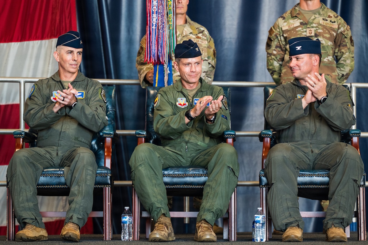 Three pilots sit and clap