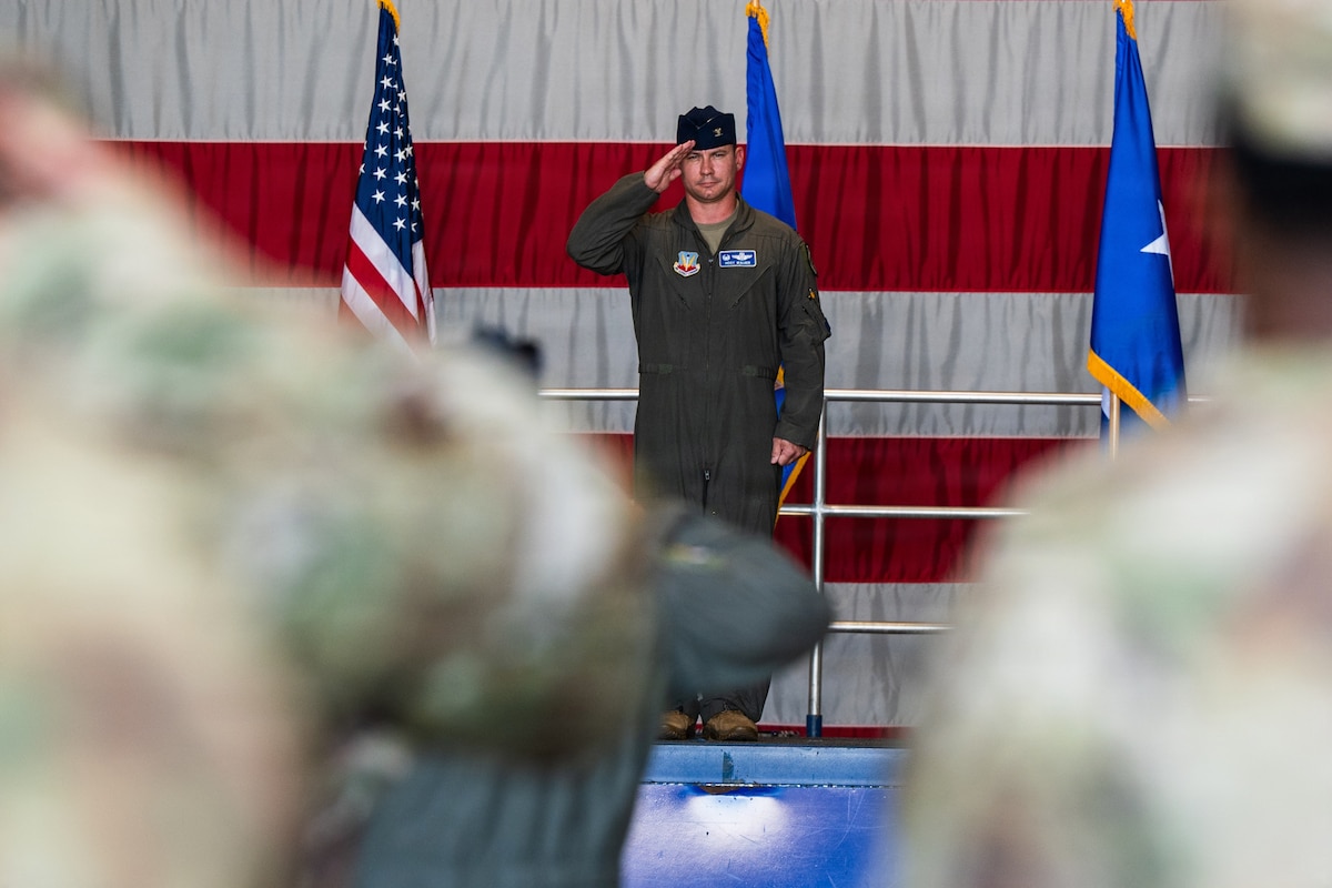 A pilot salutes a troop formation